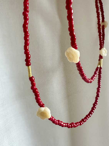 Collana perline rosse e fiori bianchi 