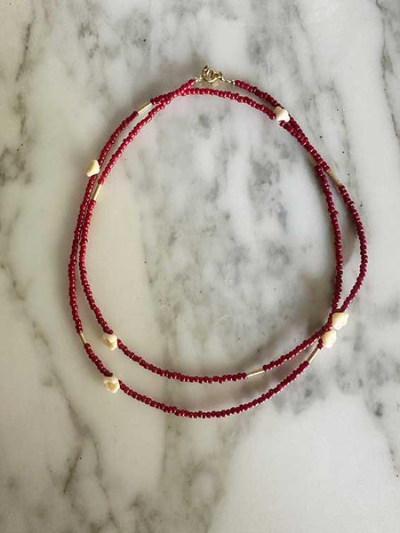 Collana perline rosse e fiori bianchi 